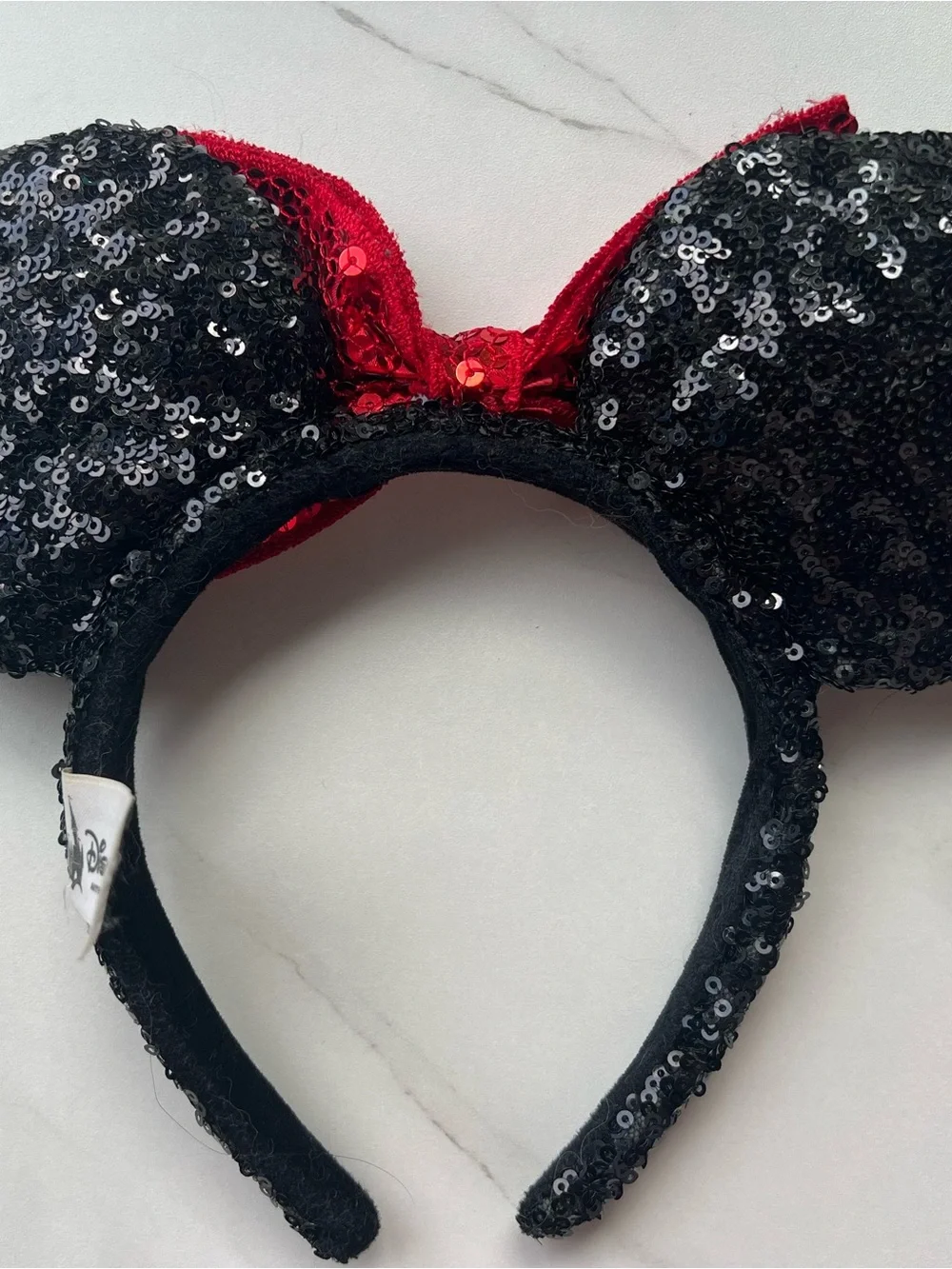 Disney Parks Authentic White Label, black sequin ears with a read sequin bow.